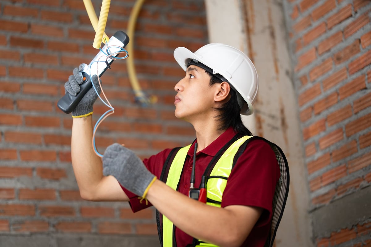 Engineer reviewing ceiling electrical installations on site